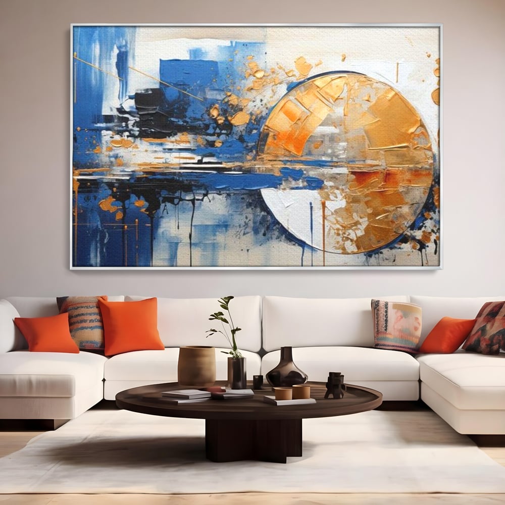 Tablou canvas cu pictura abstracta cu cerc auriu si albastru, in rama de aluminiu argintiu, pe perete intr-un living